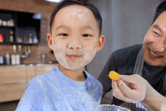 Father feeds his son egg yolk