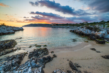 Sunset sky over beautiful beach and water bay in the greek spectacular coast line. Reflection on water, unique rocky cliffs, Greece summer top travel destination Mani peninsula Peloponnese