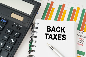 On business charts there is a calculator, a pen and a notepad with the inscription - BACK TAXES