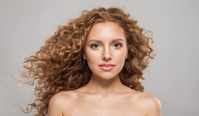 Healthy redhead female model with wavy hairstyle. Pretty young woman with healthy curly hair, fashion portrait