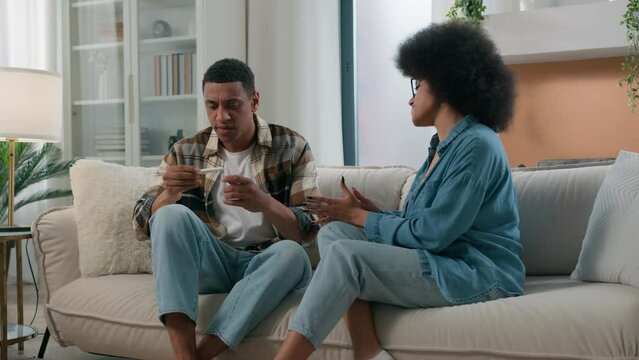 African American pregnant woman girlfriend wife showing positive pregnancy test to man husband guy frustrated shocked worried bad news unwanted unplanned quarrel at home conflict relationship trouble