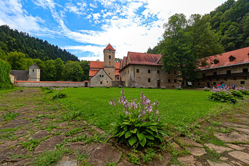 Historic monastery complex nestled in a lush green valley.