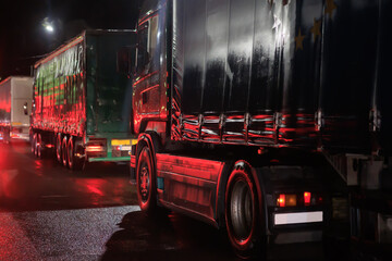 Trucks move along a country highway at night
