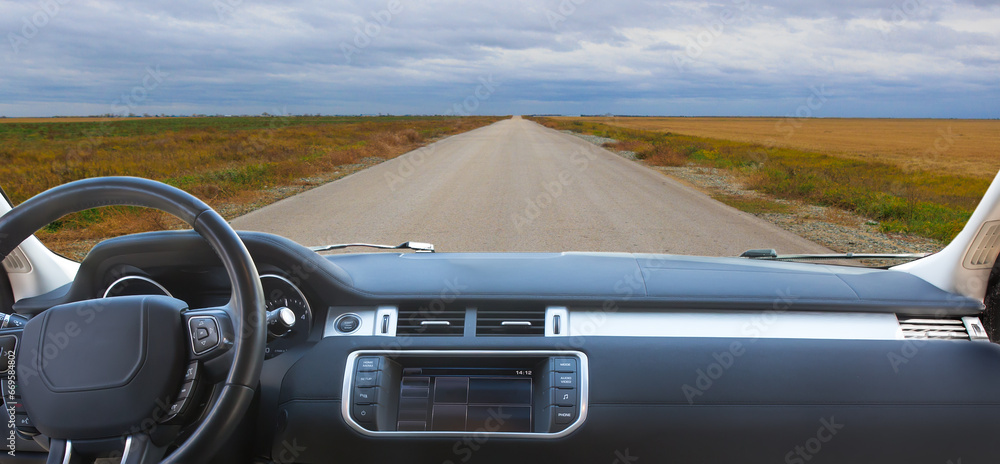 Poster view from a car to an empty country road