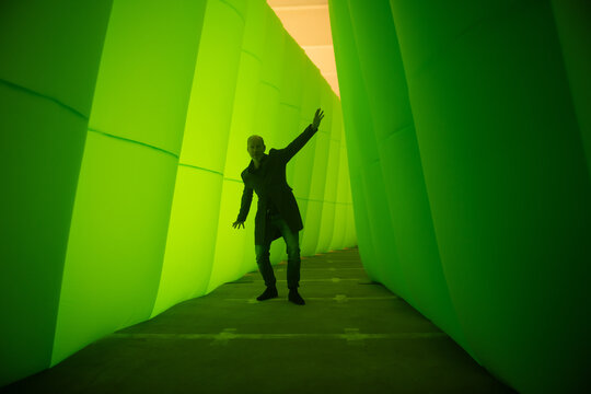 silhouette of a man doing the happy dance in a green tunnel