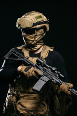 Photo of a confident and courageous military man on a dark isolated background in a camouflage...