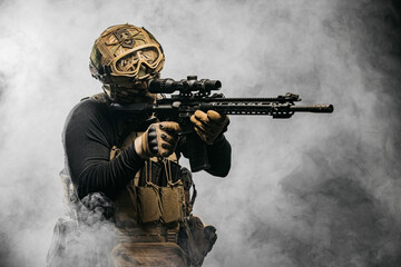 Portrait of a special forces soldier aiming at the collimator sight of a machine gun. The concept...