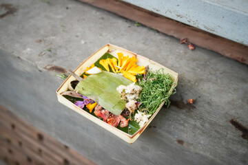 Traditional balinese offerings to gods in Bali with flowers and aromatic sticks. Balinese Hindu...