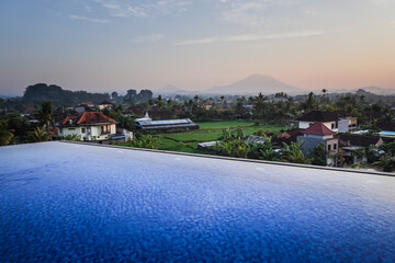 Blue swimming pool in hotel rooftop with beautiful mountain and rice paddy fields view in the...