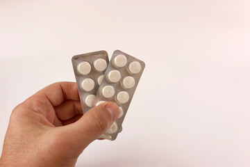 A man holds flu and cold pills in his hand. Treatment of acute respiratory diseases.