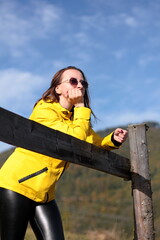 young woman traveling in the mountains, enjoying the mountain landscape, smiling in the sun