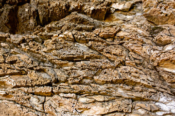Natural rock texture background. Rocky bas-relief wall.