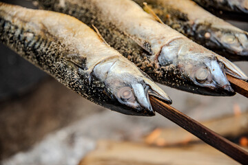 Barbecue stockfish grilled trout fish on stocks with fire smoke
