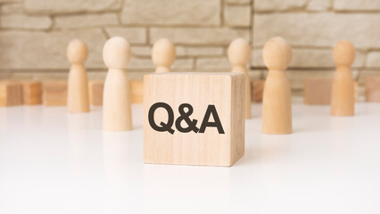 Q and A - 'Question and Answer' wooden blocks with letters, help concept, front view on grey...