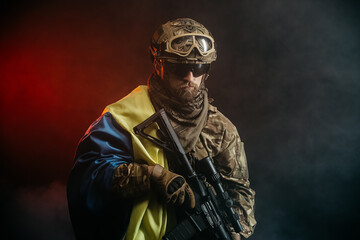 Ukrainian special forces soldier or private military contractor with rifle and Ukrainian flag....