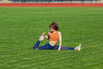 Fit caucasian woman doing stretching exersices at outdoor stadium