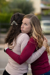 Hypocritical girl hugs a friend but gets bored of being close to her. Fake Friendship concept