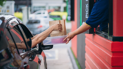 Young Man receiving coffee at drive thru counter., Drive thru and take away for protect covid19..