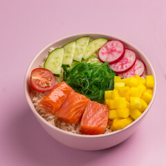Traditiona Hawaiian red fish poke bowl with rice, radish,cucumber, tomato, and seaweeds. Buddha bowl. Diet food. Flat lay.