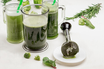 Mugs with green vegetable smoothies.