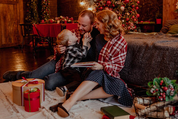 New Year's or Christmas Eve with happy family reading book to child
