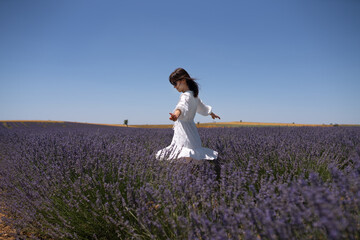 Beautiful young woman running in a lavender field
