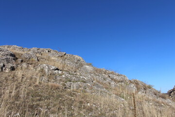 A grassy hill with a hill in the background