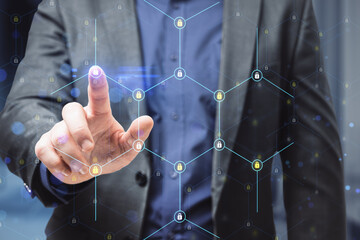 Close up of businessman hand pointing at creative glowing hexagonal pattern with tiny padlocks on blurry office interior background. Digital security and firewall concept. Double exposure.