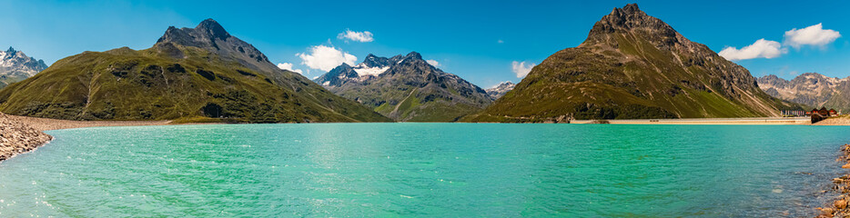 High resolution stitched alpine summer panorama with reflections in a lake at Sylvretta reservoir,...