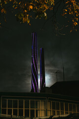 Two chimneys at night lid by colorful lights