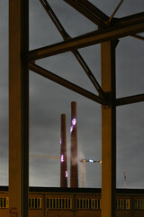 Two chimneys at night lid by colorful lights