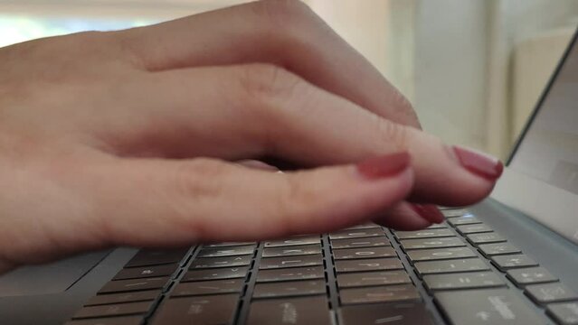 Close up side view of female hands of typing keyboard on laptop at office desk. concept of working online with pc software apps technology 
