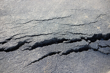 Cracks of the road asphalt. Cracked asphalt texture close-up.
