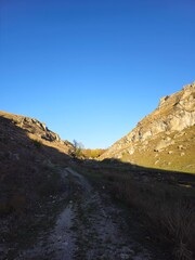 A rocky cliff with a stream running through it
