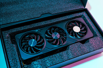 video card for a computer with three fans lies in holders in the shipping box