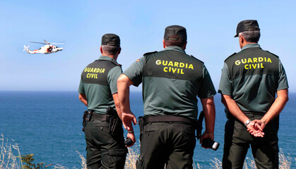 Three guards observe a rescue, rescue at sea, missing man, man now in the sea, rescue helicopter