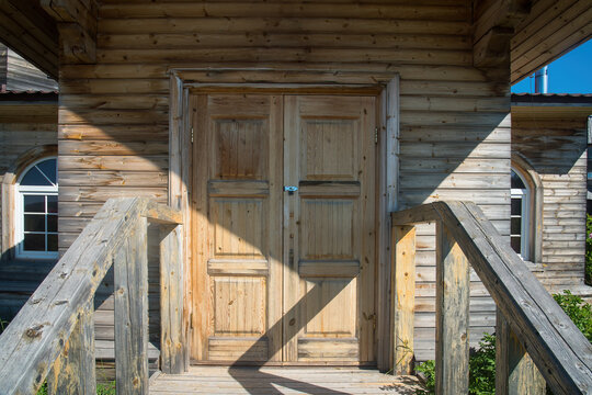 a massive wooden door to a log house. buildings in the village