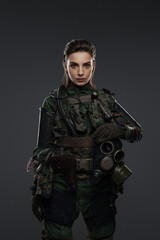 Portrait of a woman in military attire, portraying a rebel or partisan, against a gray background, depicting a Middle Eastern conflict