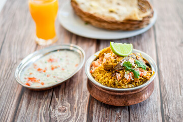Spicy Indian biryani pulao in golden bowl with India basmati rice dish with chicken meat curry