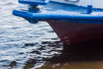 the bow of the vessel with a draft marking in river water