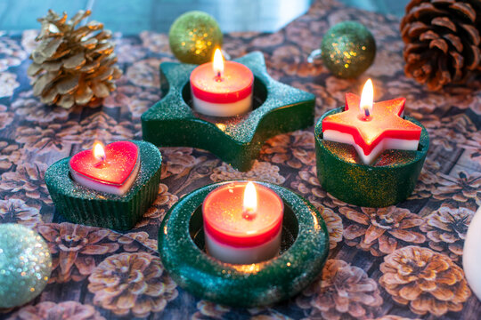 Weihnachtskerzenhalter für Teelichter aus Gips mit brennenden Kerzen. Handgemacht in grün mit Glitzerstaub.