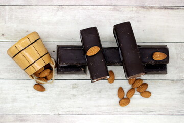 chocolate bar with almonds on a white wooden