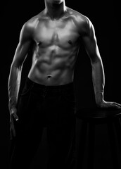 Fototapeta na wymiar Silhouette of a slender muscular man doing sports in the gym. Sports and healthy lifestyle.