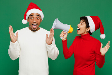 Merry amazed young couple friend man woman wear red casual clothes Santa hat posing scream in...