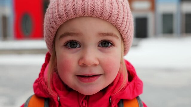 Winter portrait of little 2 years old girl smiling looking at camera