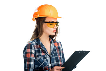 A Professional Woman Inspecting Construction Site with Confidence and Expertise. A woman wearing a hard hat and glasses holding a clipboard