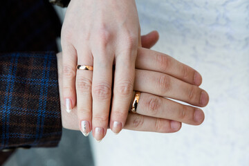 Hands of a Couple Showcasing Gold Wedding Bands