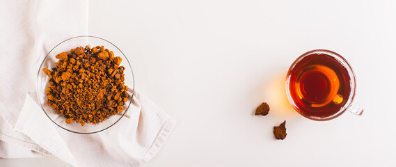 Healing tea from wild birch chaga mushroom in a cup on the table top view web banner