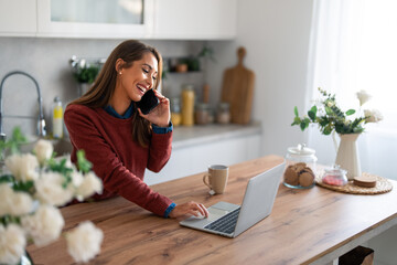 Happy satisfied businesswoman using modern smartphone in her home office at early morning about to...