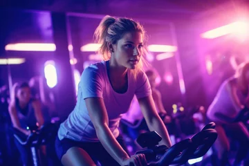 Wandaufkleber Portrait of beautiful woman working out at gym, running on bicycle and doing fitness exercises. healthy concept with LED lights © aboutmomentsimages